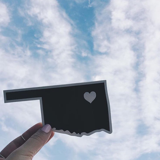 Black sticker of Oklahoma with a white heart showing Tulsa—perfect for local pride or Oklahoma souvenirs