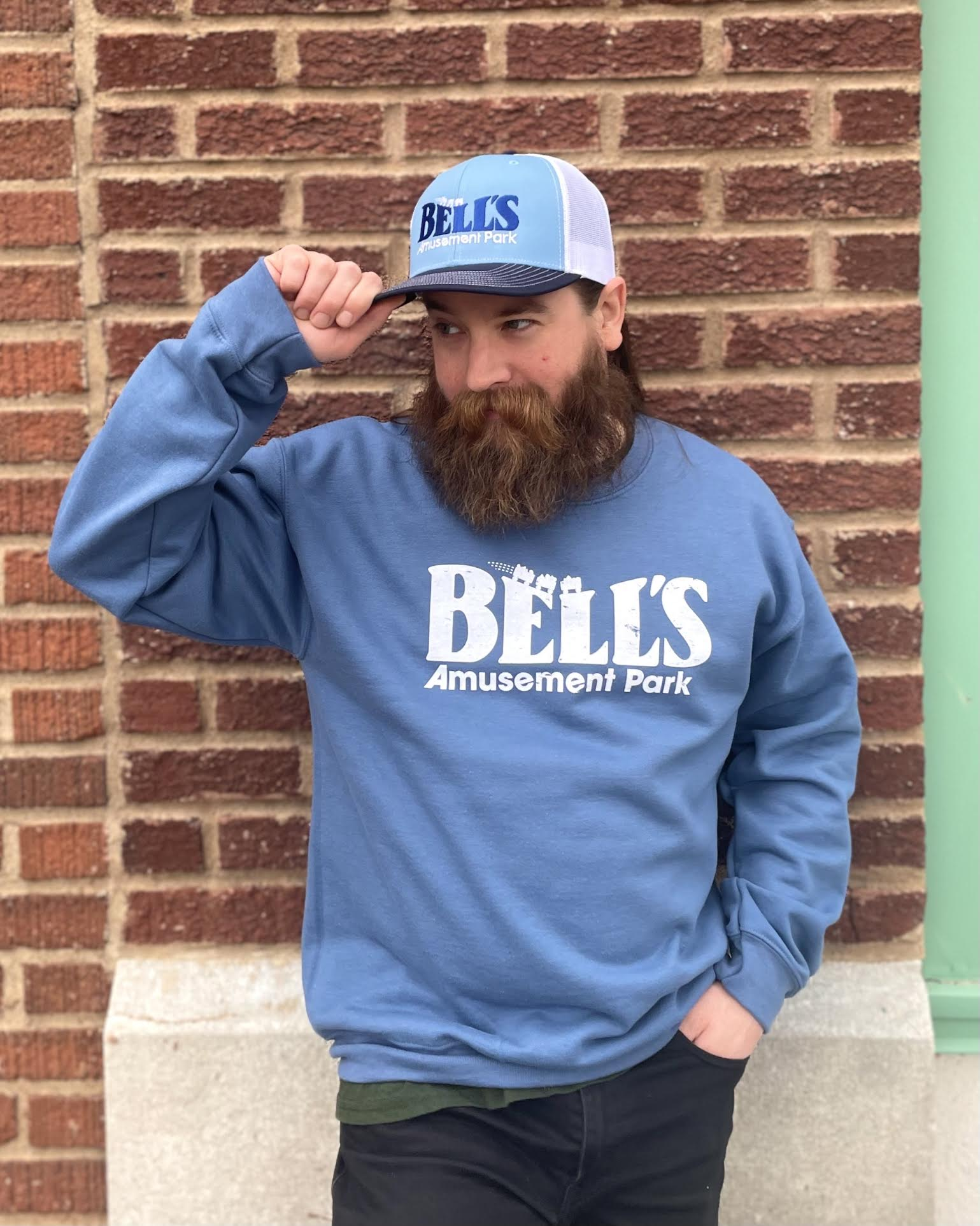 Man with beard wearing a Blue Bell's Amusement Park sweatshirt and hat