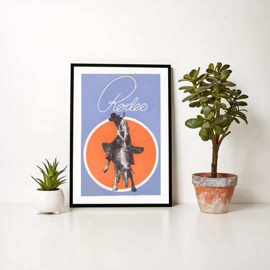 Vintage rodeo print featuring cowboy on a bronco with bold orange and blue design.
