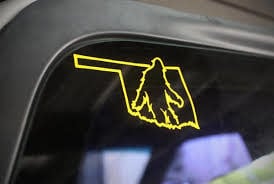 Vinyl window decal of Oklahoma state outline with Bigfoot silhouette
