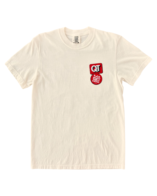 An off-white crewneck t-shirt with a small red and white graphic on the left chest, displayed flat against a white background.