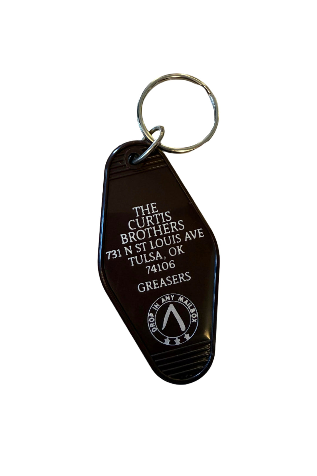 Brown motel-style key tag reading The Curtis Brothers with address and Greasers text