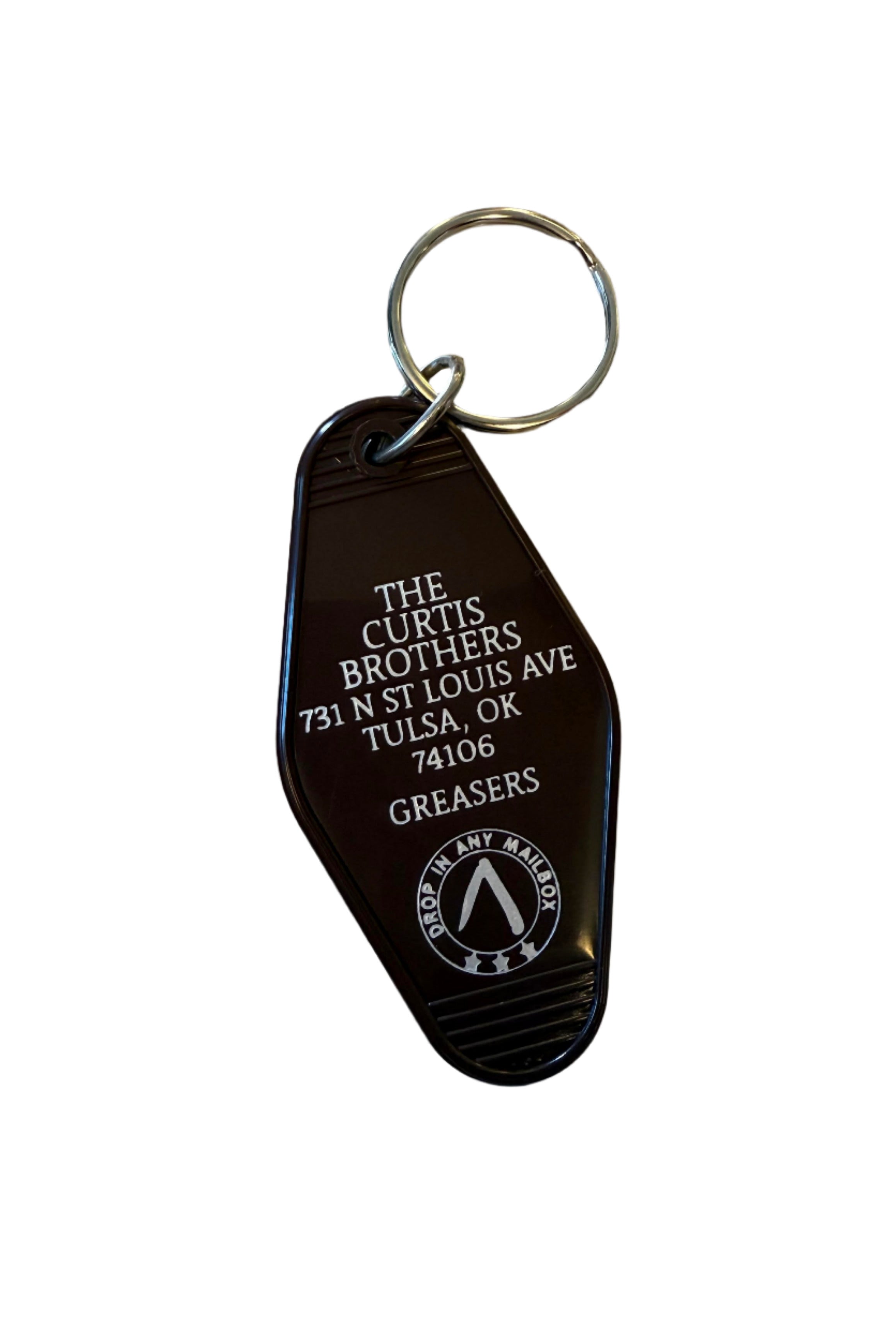 Brown motel-style key tag reading The Curtis Brothers with address and Greasers text