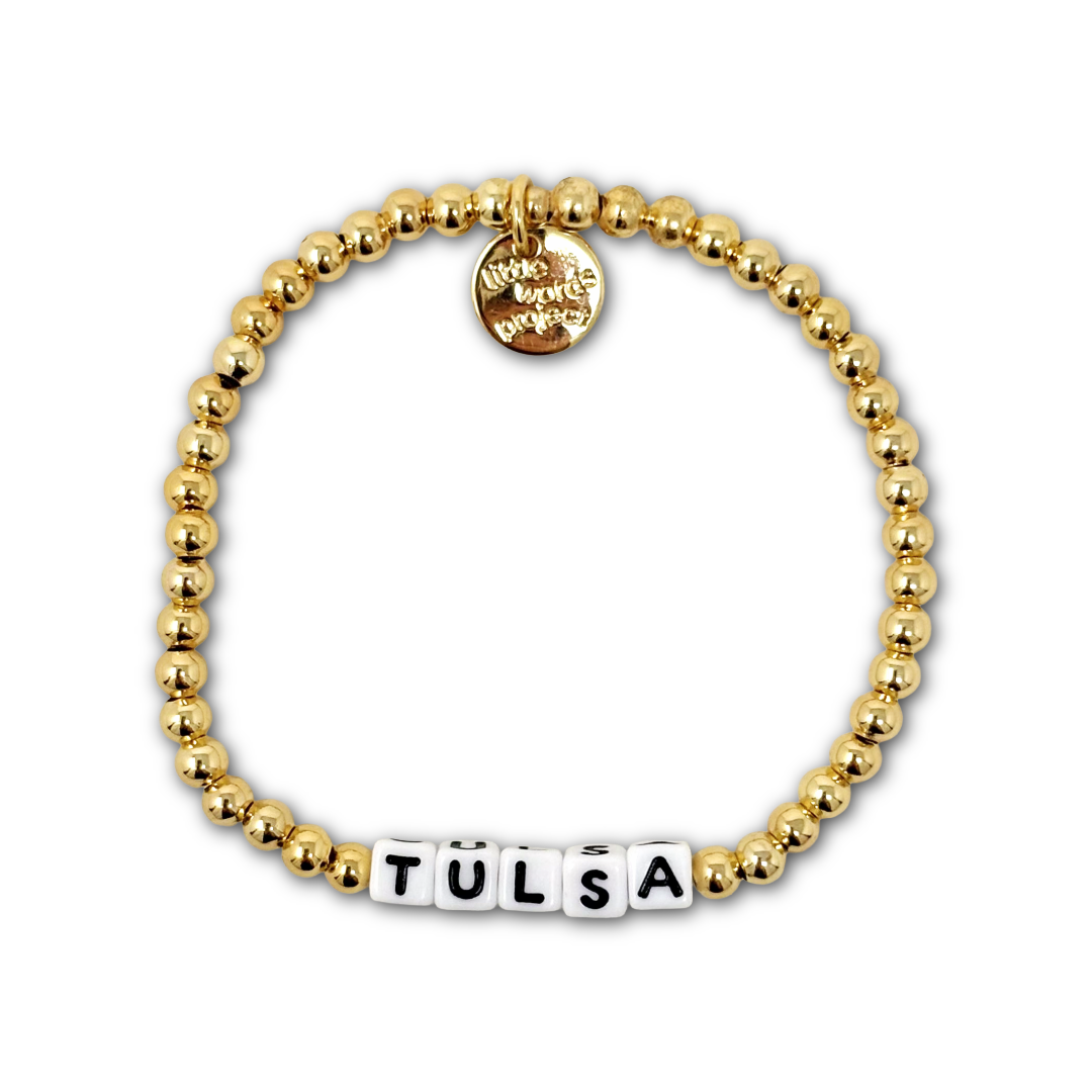 Bracelet with gold beads and letter beads spelling out "TULSA".