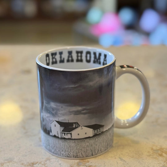Black and white coffee mug with tornado and field design and "Oklahoma" on the inside