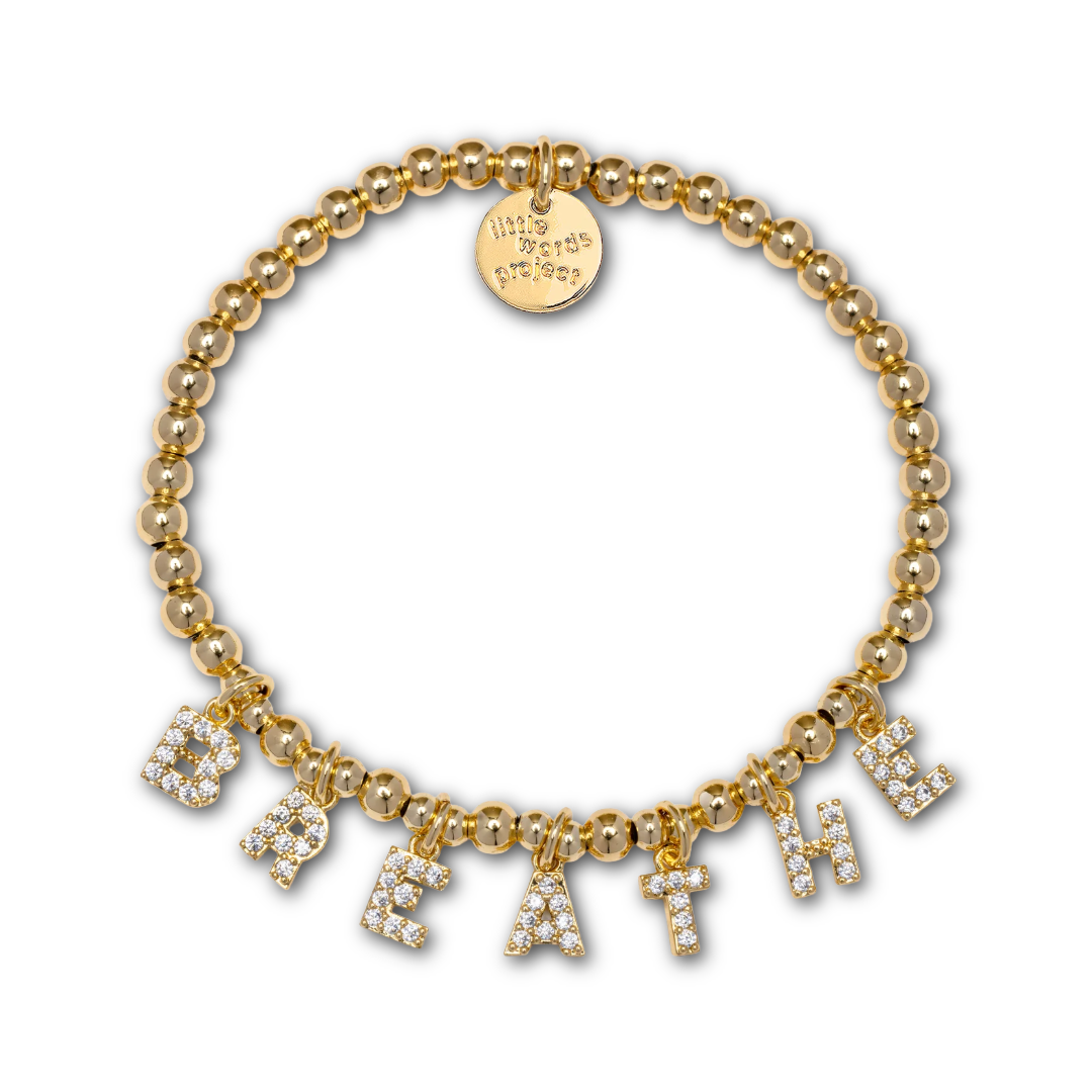 Gold beaded bracelet with gold and rhinestone letter-shaped charms spelling out "BREATHE".