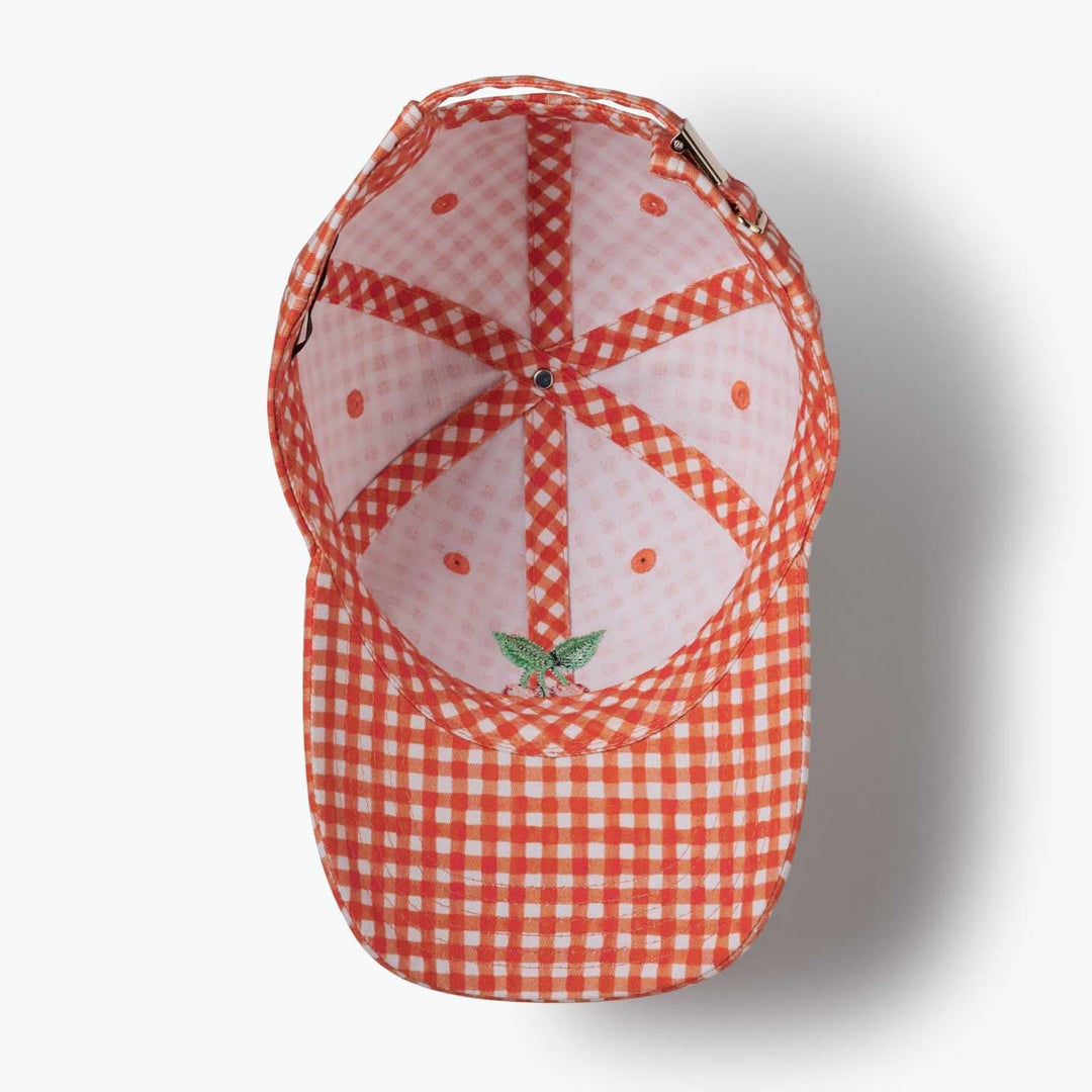 Red and white checkered cap with a small cherry design on a light gray background