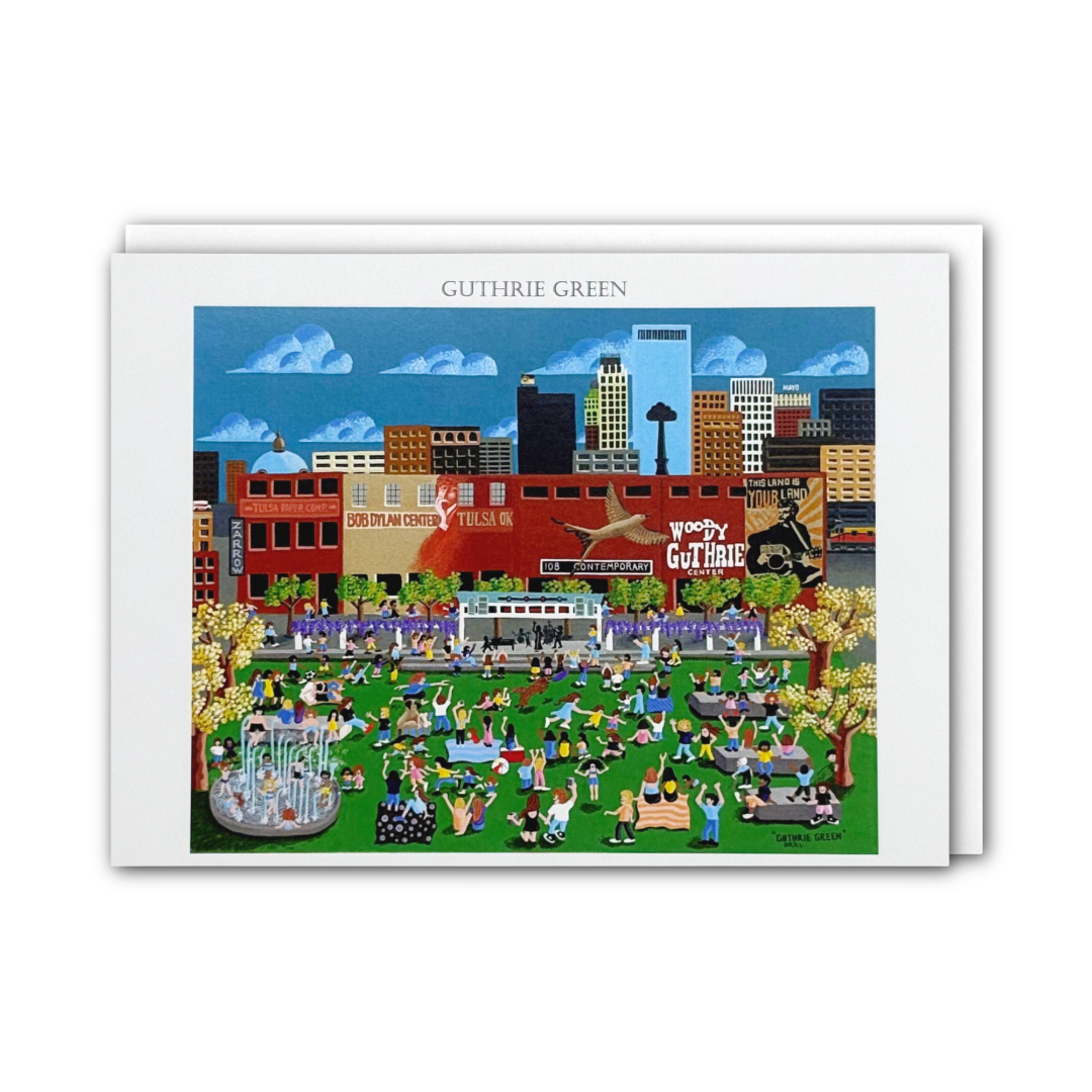 A card featuring a colorful illustrated city scene with people in a park, buildings, trees, and a blue sky. The name 'GUTHRIE GREEN' appears at the top, and a white envelope is partially visible behind the print.