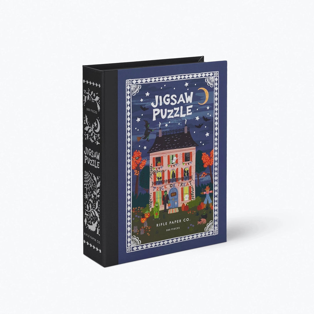 A jigsaw puzzle box styled to look like a book, shown at an angle on a light gray background. The front features an illustrated night scene with a house, stars, moon, and the words 'JIGSAW PUZZLE.