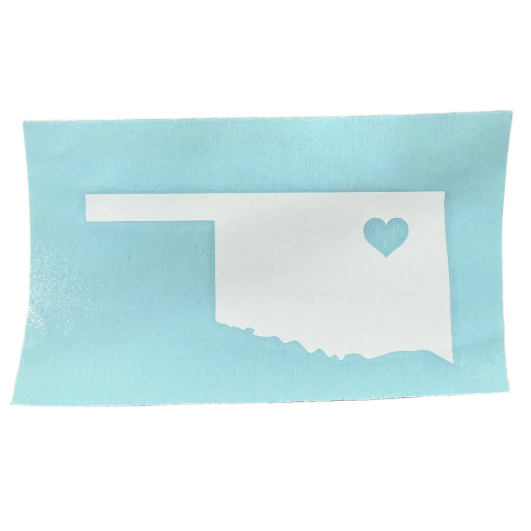 White vinyl car decal of Oklahoma with a clear heart cutout over the city of Tulsa