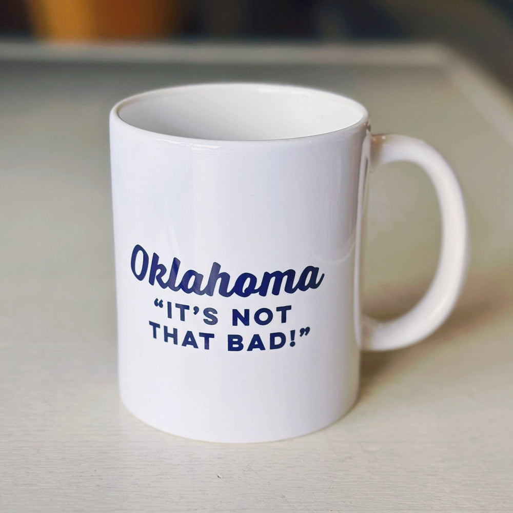 White coffee mug with black text saying "Oklahoma It's Not That Bad," perfect souvenir for Oklahoma tourists and locals