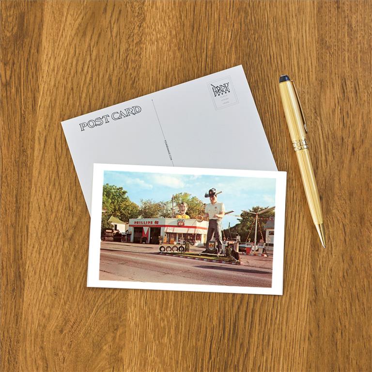 Route 66 Gas Station with Giant Man Holding Tire Postcard