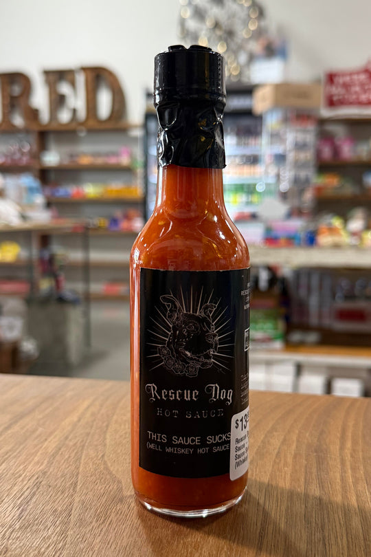 Hot sauce bottle labeled “This Sauce Sucks” with bold design from Oklahoma-based Rescue Dog Hot Sauce