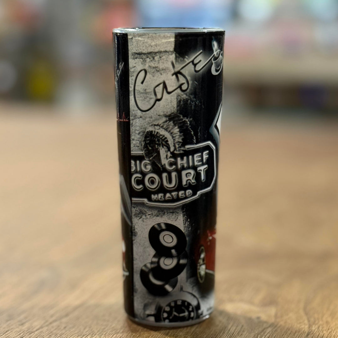 Vintage Route 66 shot glass decorated with neon diner signs, classic gas pumps, and iconic road imagery