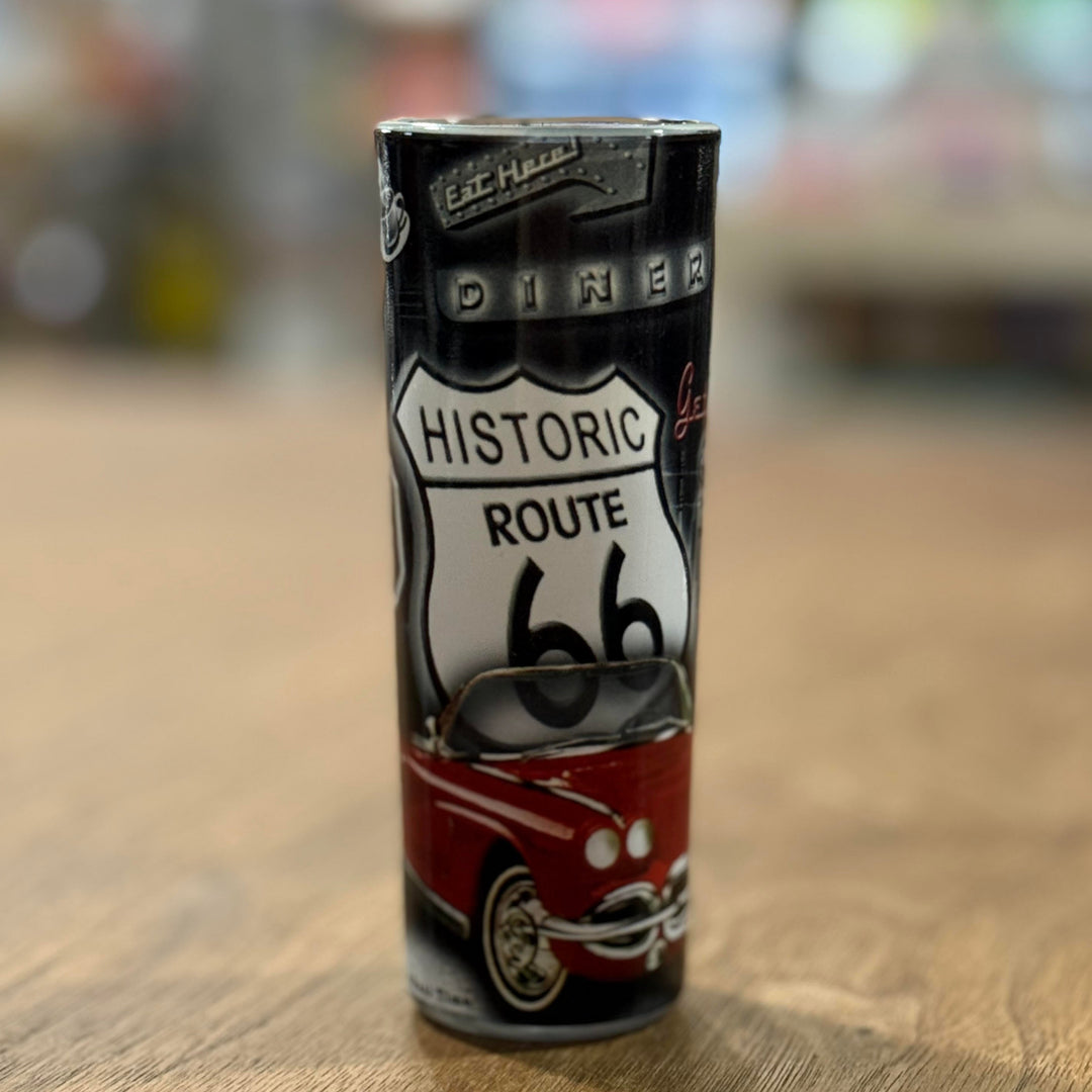 Vintage Route 66 shot glass decorated with neon diner signs, classic gas pumps, and iconic road imagery