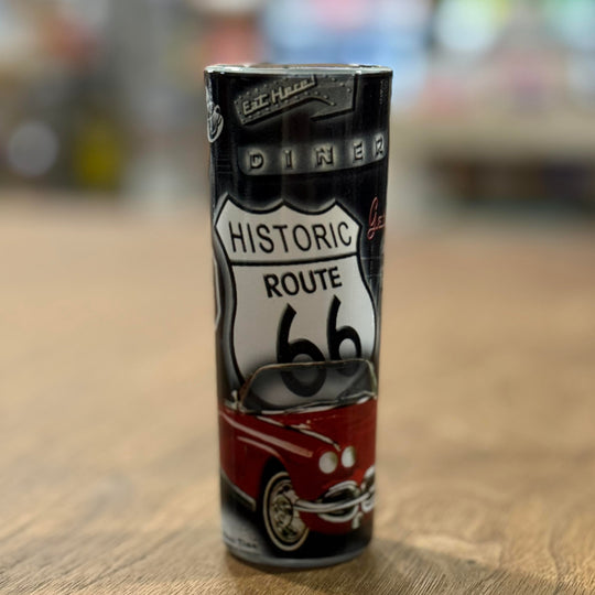 Vintage Route 66 shot glass decorated with neon diner signs, classic gas pumps, and iconic road imagery